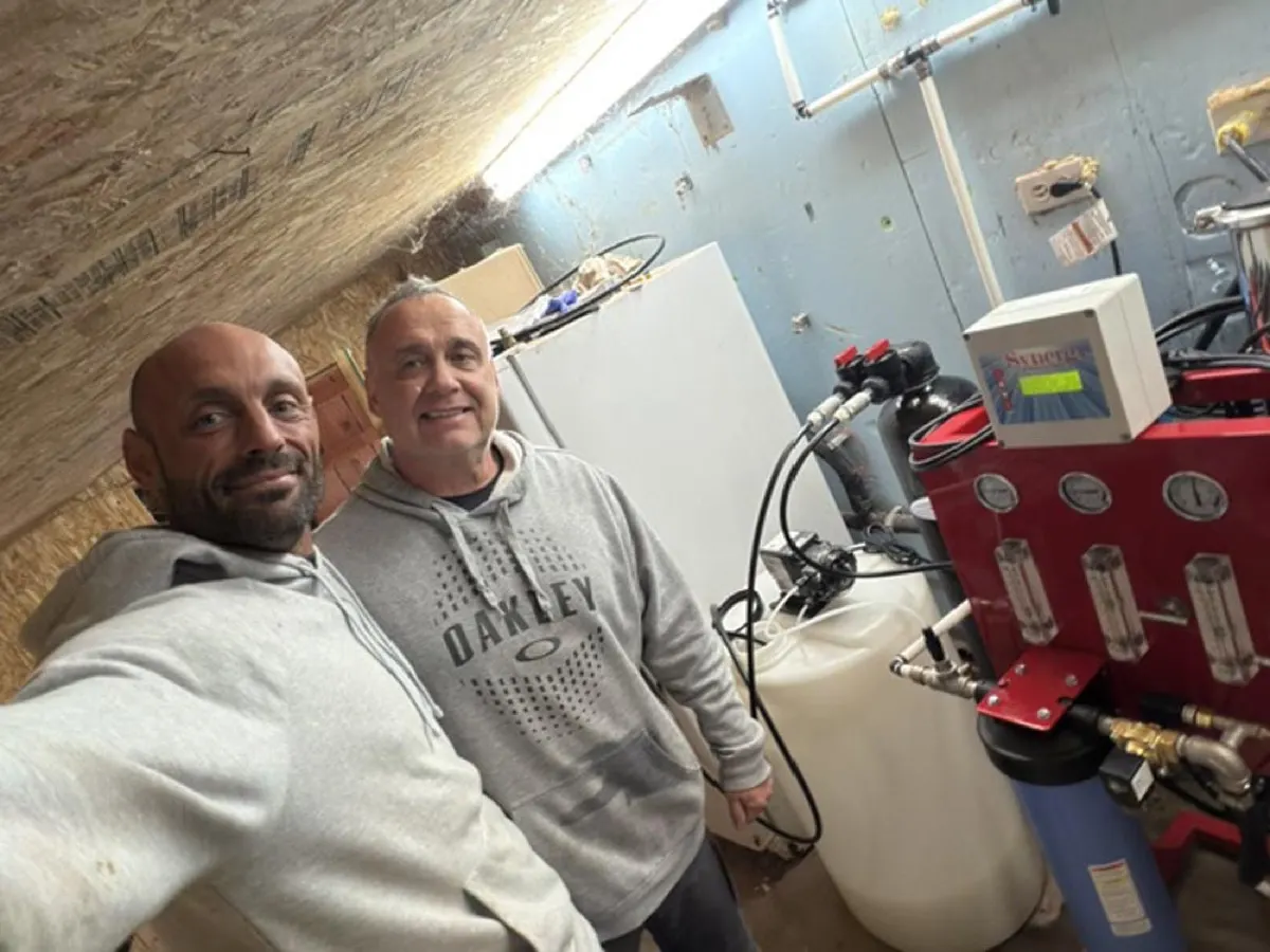 Technician and a customer beside a reverse osmosis system