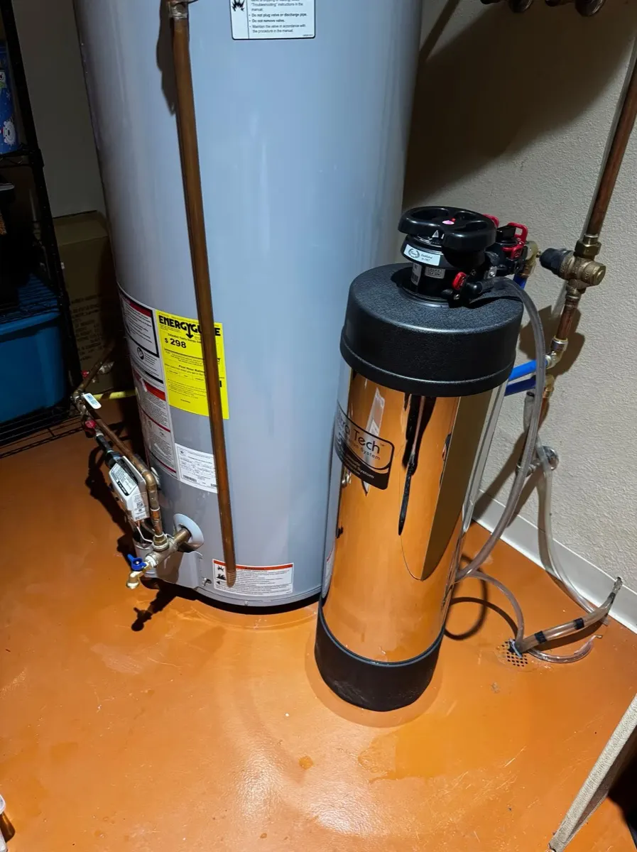 Stainless whole-home filter installed beside a water heater
