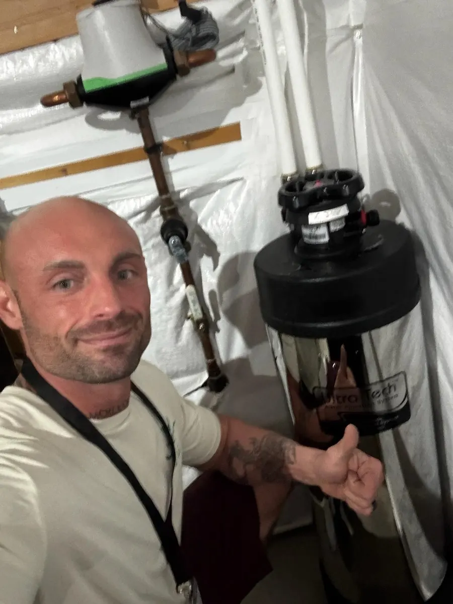 Technician with a stainless whole-home system ready for installation
